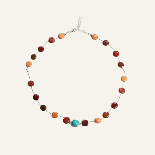 Un collier de perles avec une pierre turquoise