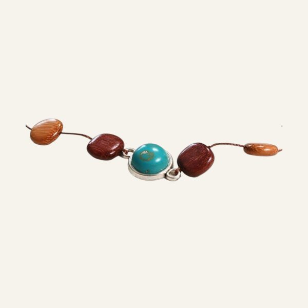 Un bracelet avec une pierre bleue et des perles brunes