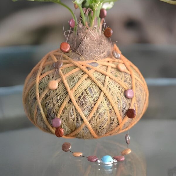 Un collier à perles avec une pierre turquoise exposé sur une plante