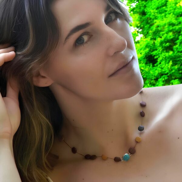 Une femme avec un collier à perles avec une pierre turquoise
